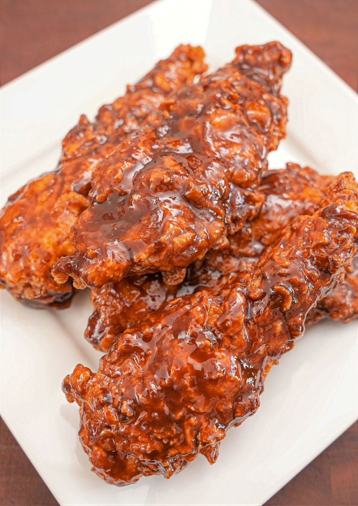 A plate of Korean Honey Butter Fried Chicken stacked on top of each other.