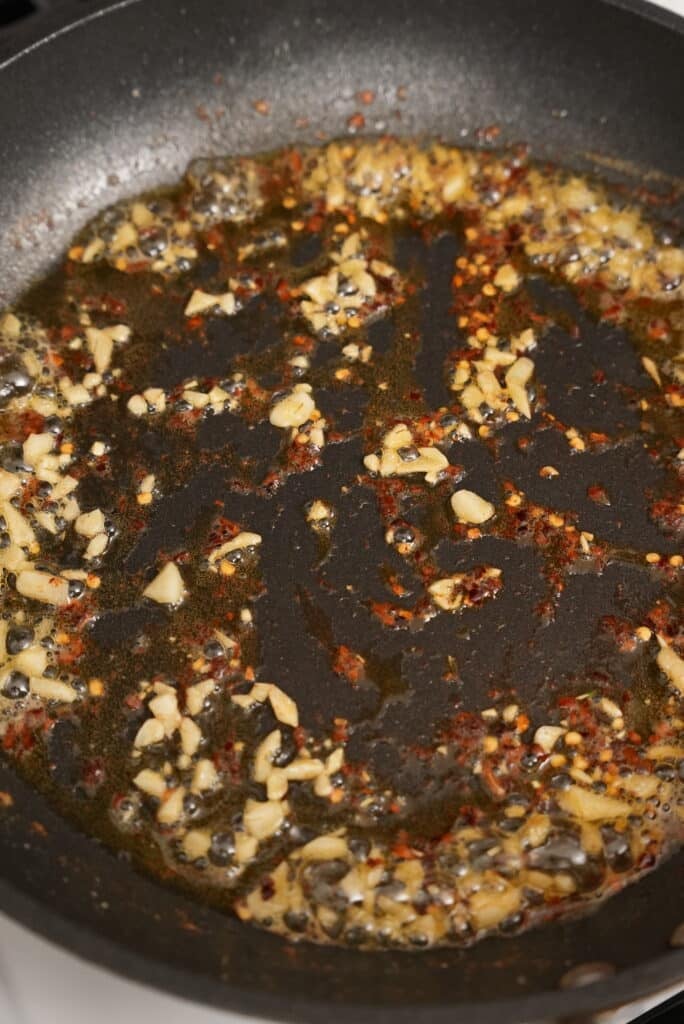 Frying garlic and crushed red pepper in olive oil and butter