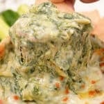 Close up of Spinach Artichoke dip with a tortilla chip