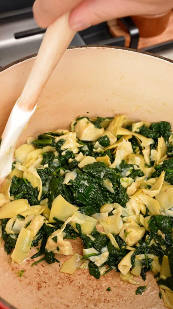 Cooking artichoke hearts with spinach in a pot