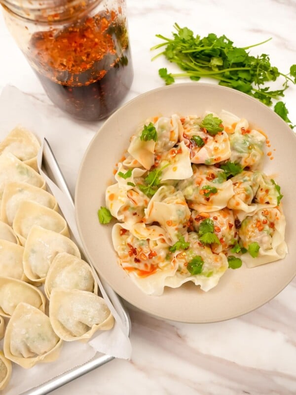 Chicken and cilantro wontons on a plate with chili oil