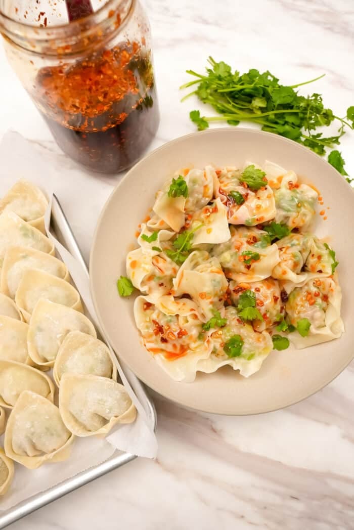 Chicken and cilantro wontons on a plate with chili oil