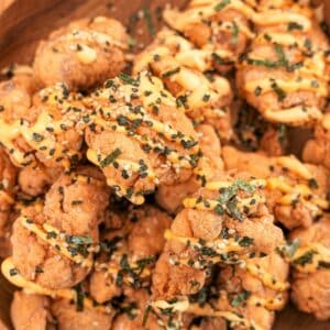 Crispy Mochiko Chicken in a wooden bowl with furikake and a spicy mayo sauce.