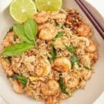 Thai Basil Fried Rice in a bowl with limes and chopsticks.