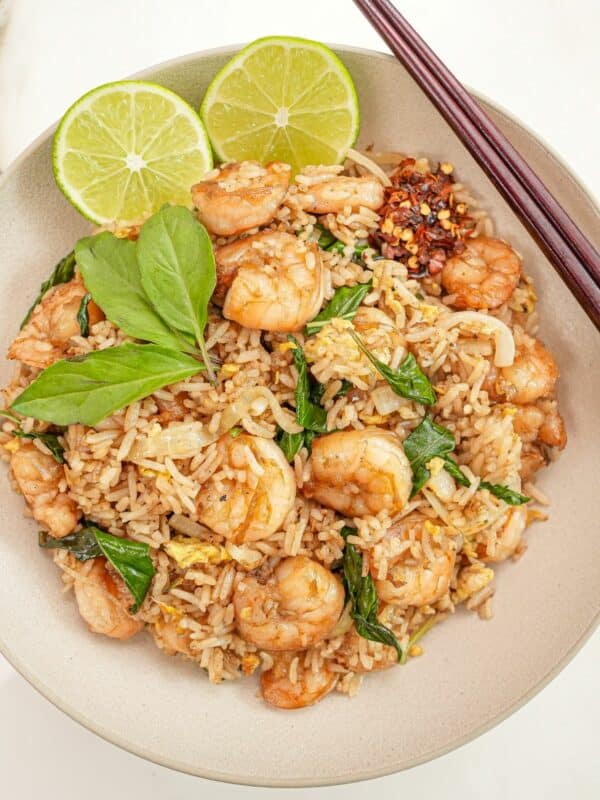 Thai Basil Fried Rice in a bowl with limes and chopsticks.