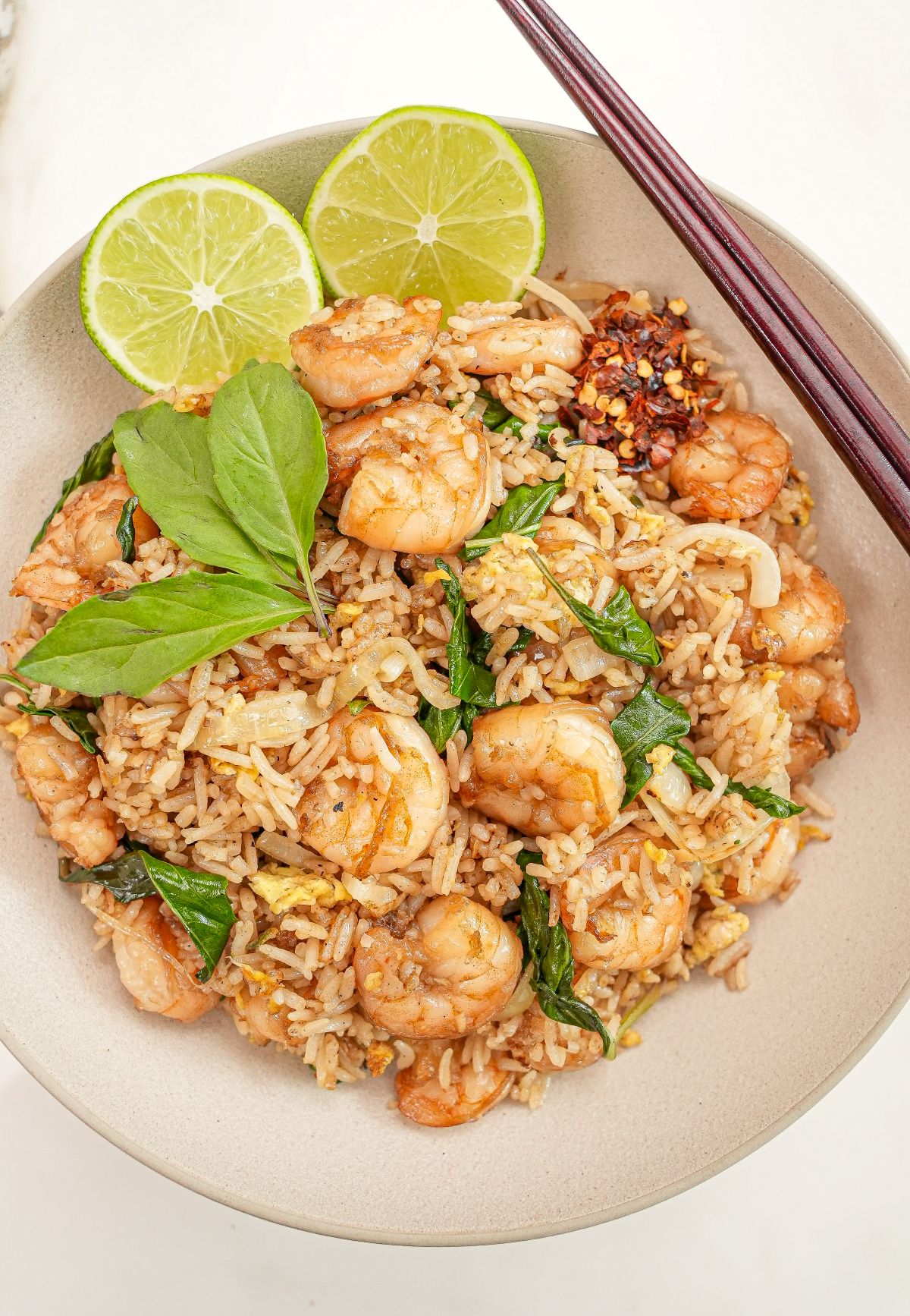 Thai Basil Fried Rice in a bowl with limes and chopsticks.