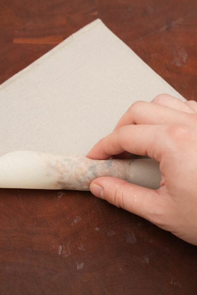 Wrapping an egg roll with hands