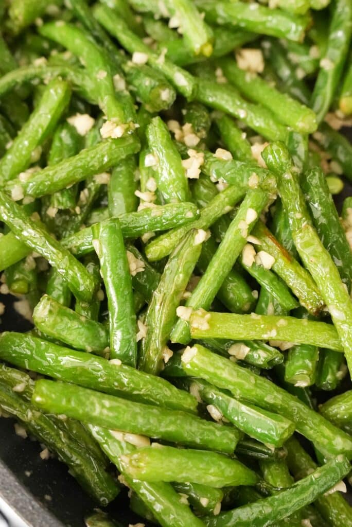 Green Beans tossed with garlic and spices in a pan