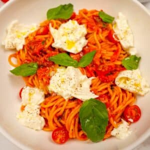 A bowl of Cherry Tomato Pasta with basil and burrata cheese.