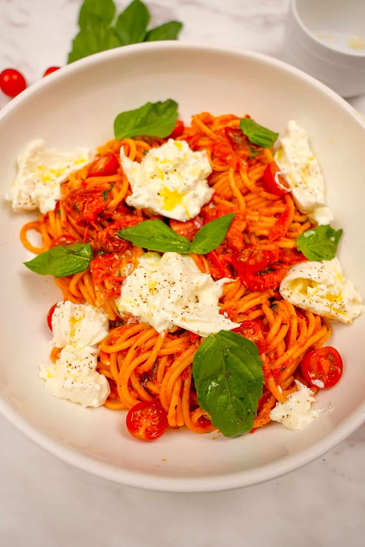 A bowl of Cherry Tomato Pasta with basil and burrata cheese.