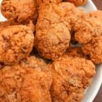 A plate of crispy fried chicken pieces on a white plate.