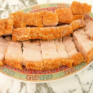Air fryer crispy pork belly cut up on a plate.