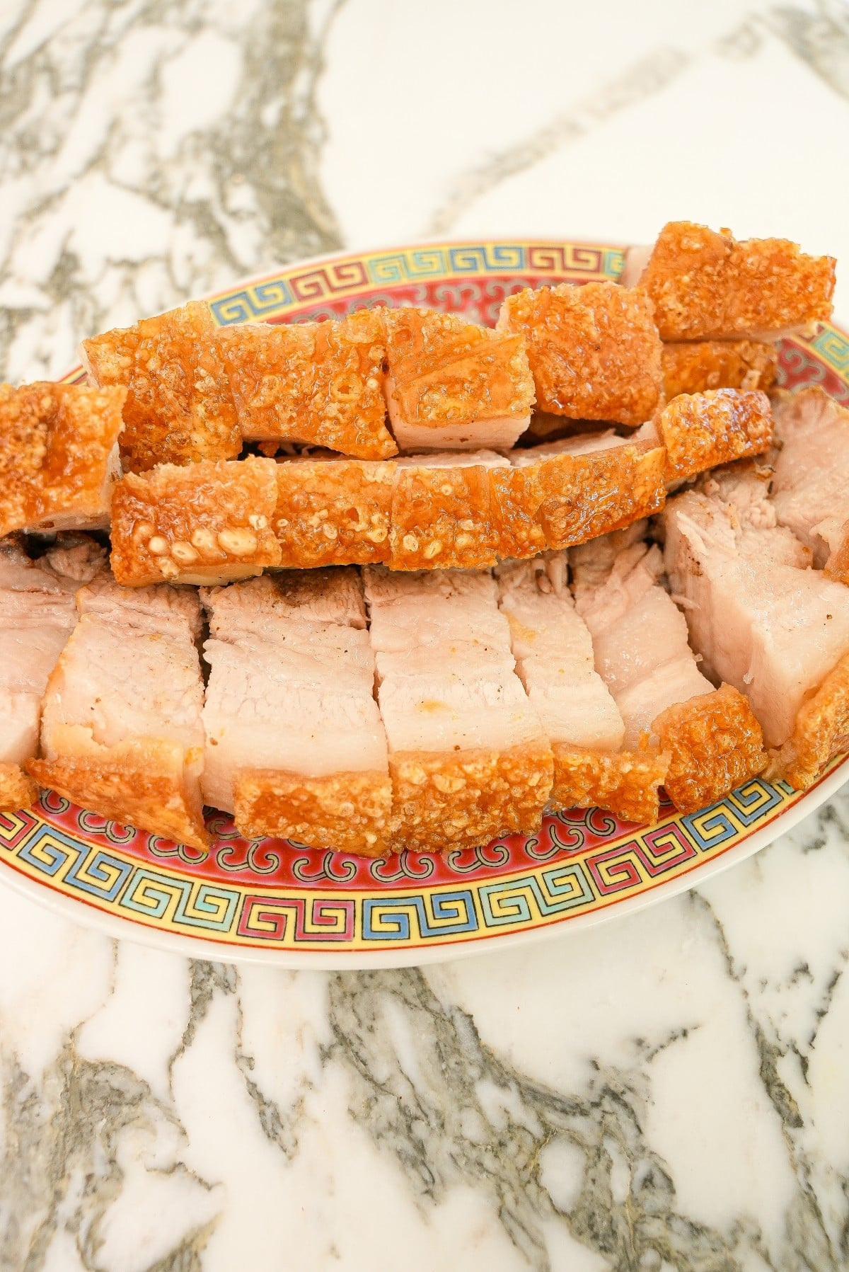 Air fryer crispy pork belly cut up on a plate.