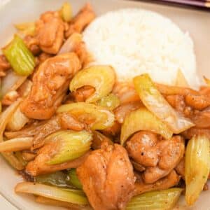 Black Pepper Chicken in a bowl with rice and chopsticks.
