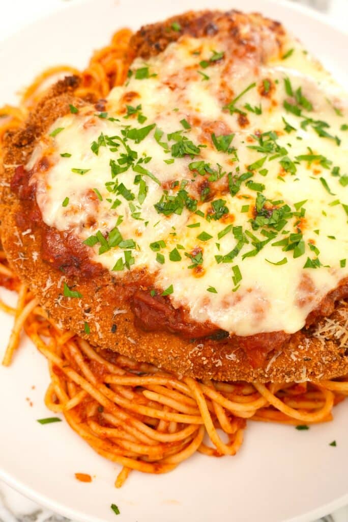 Crispy Chicken Parmesan plated on spaghetti and sauce