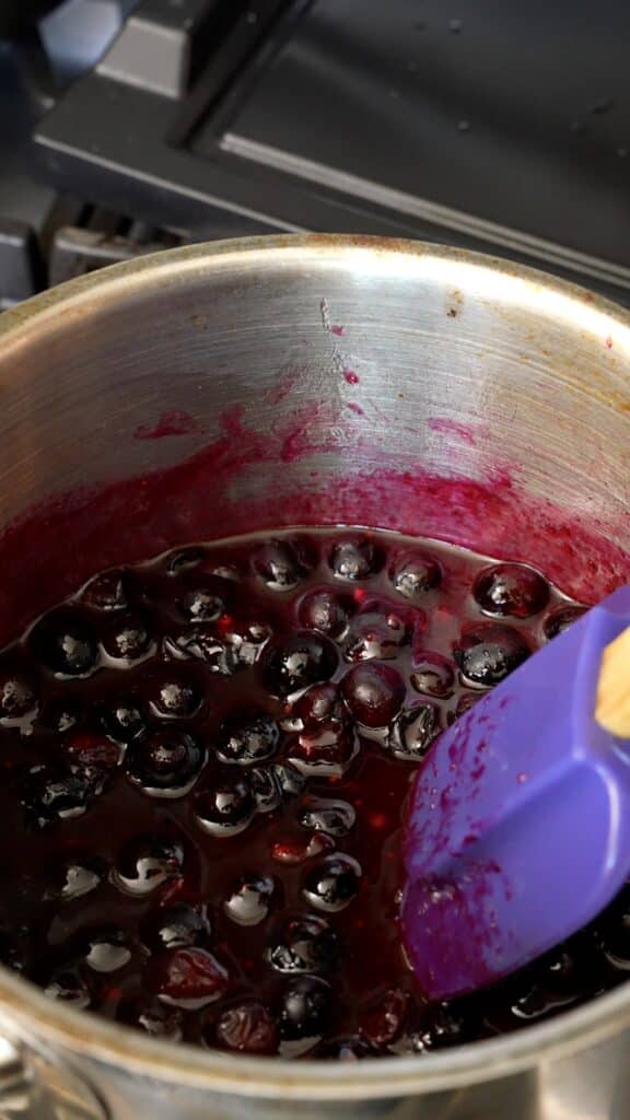 blueberry compote mixed in a saucepan for lemon ricotta pancakes