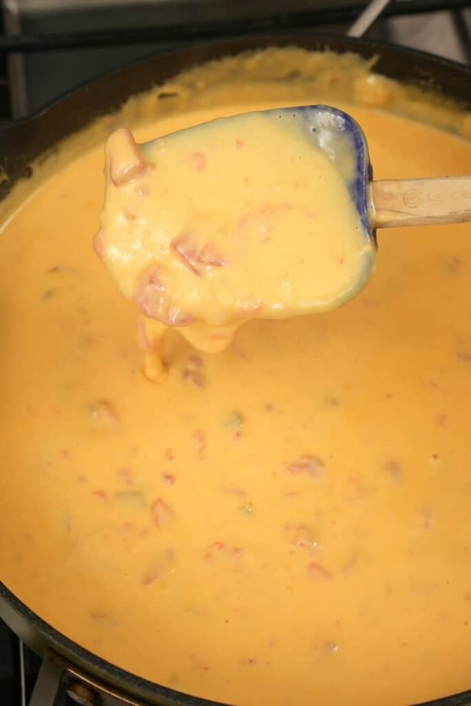 Queso dip in a pan with a spatula.