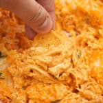 Buffalo chicken dip scooped in a bowl with corn chips.