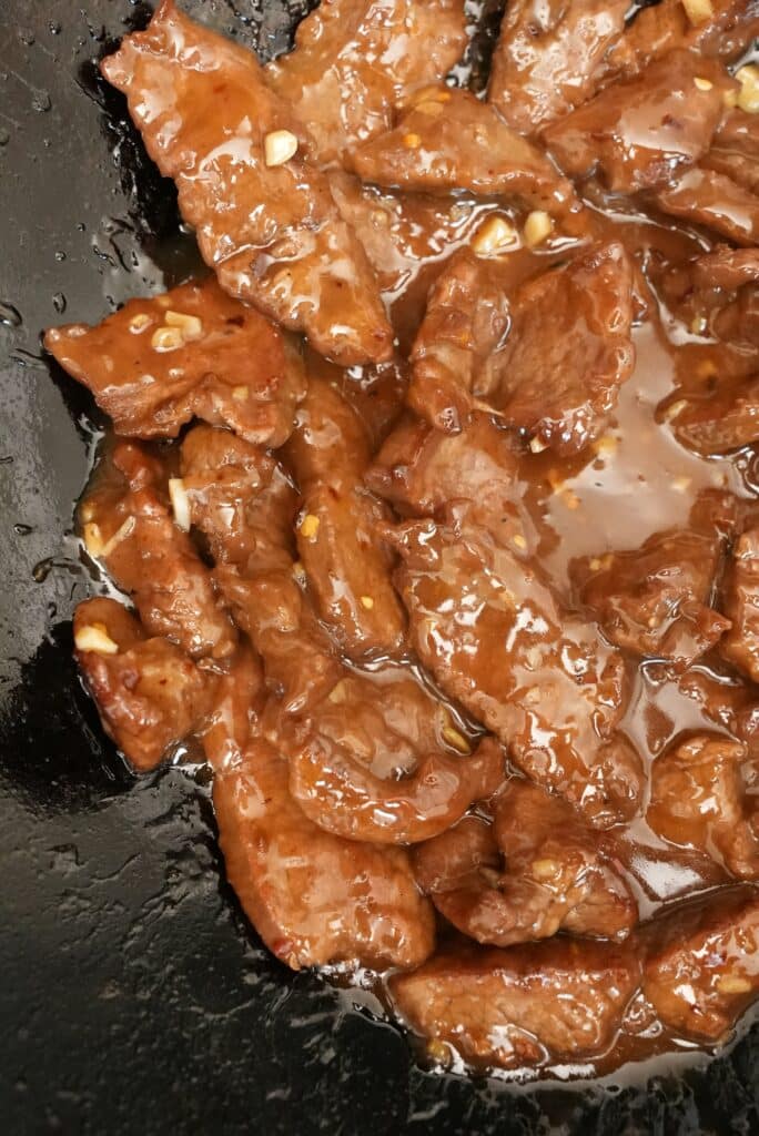 Close up of orange beef cooking in a wok
