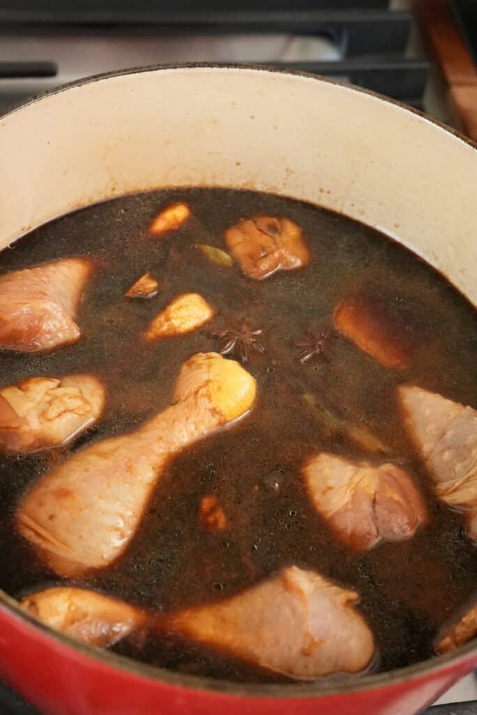 Chicken added to soy sauce poaching liquid