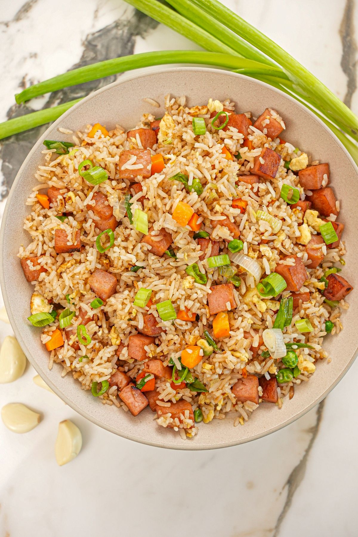 Spam Fried Rice in a bowl with vegetables, garlic, spam and scallions.