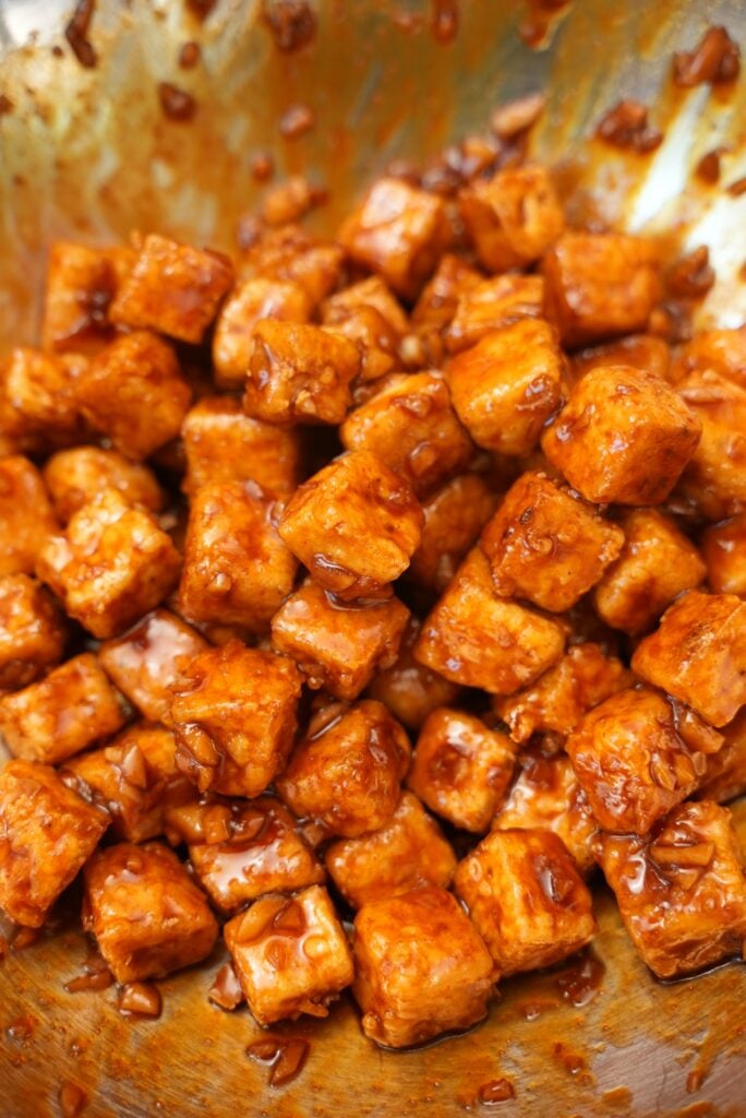 Close up of spicy honey garlic tofu mixed in a bowl