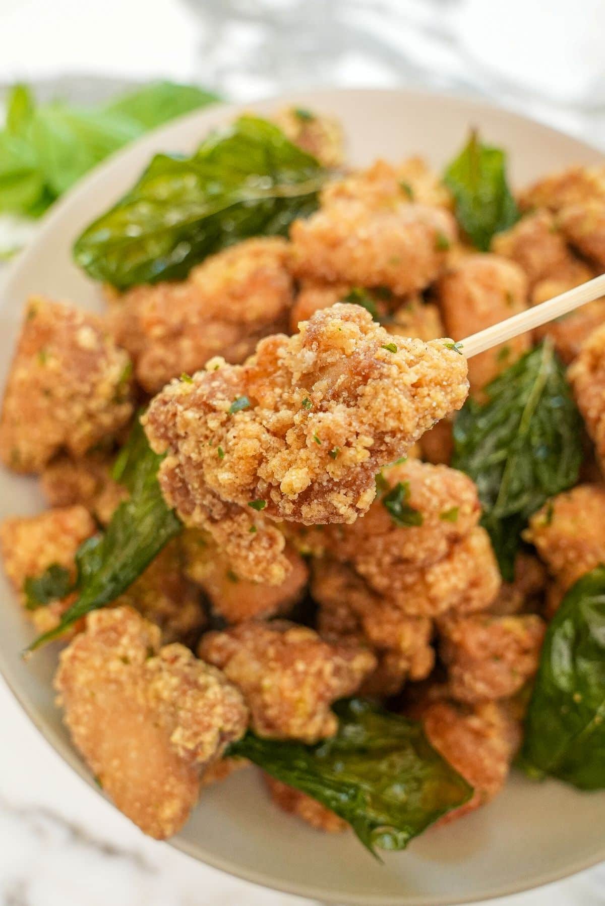 Crispy Taiwanese Popcorn Chicken in a bowl with fried basil.