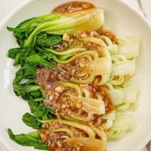 A bowl of bok choy with garlic sauce.