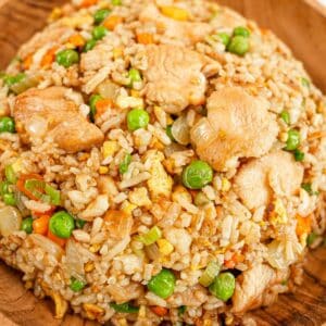 Chicken fried rice in a wooden bowl.
