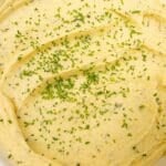 Creamy mashed potatoes in a bowl with chives.
