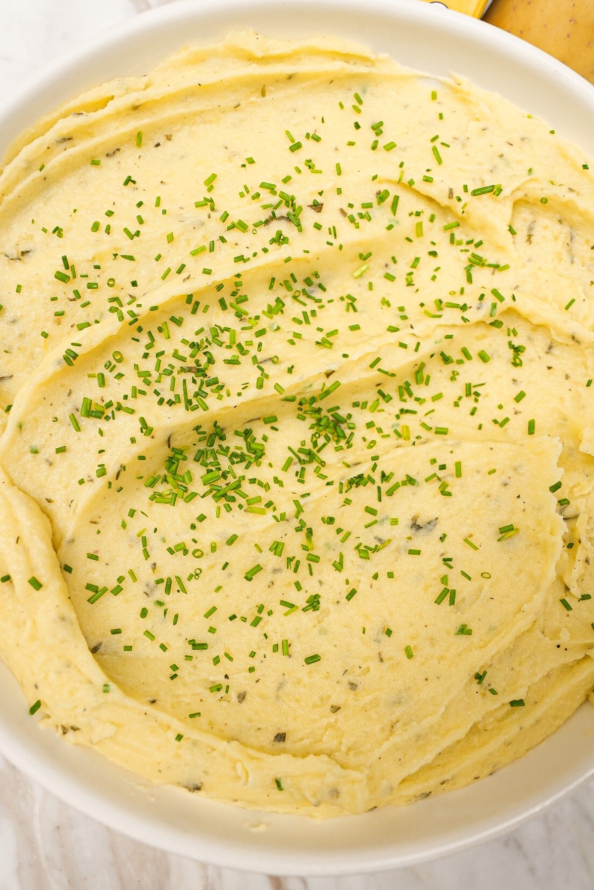 Creamy mashed potatoes in a bowl with chives.