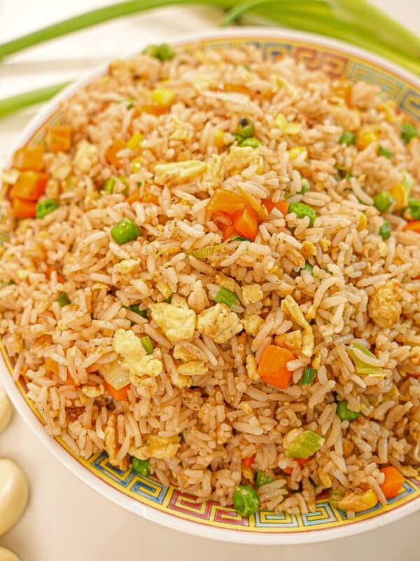 Egg Fried Rice on a plate with eggs, carrots, pea, rice, and seasonings.