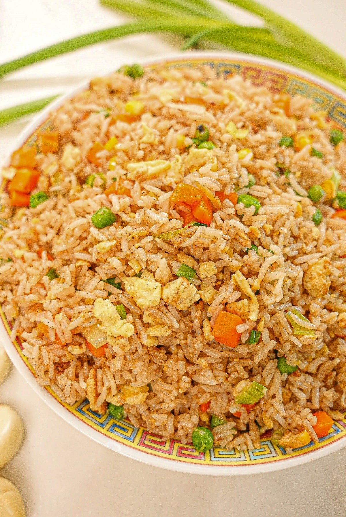 Egg Fried Rice on a plate with eggs, carrots, pea, rice, and seasonings.