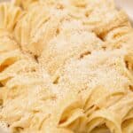 A bowl of plated Fettuccine Alfredo made with fettuccine pasta, butter, parmesan cheese, and pasta water.
