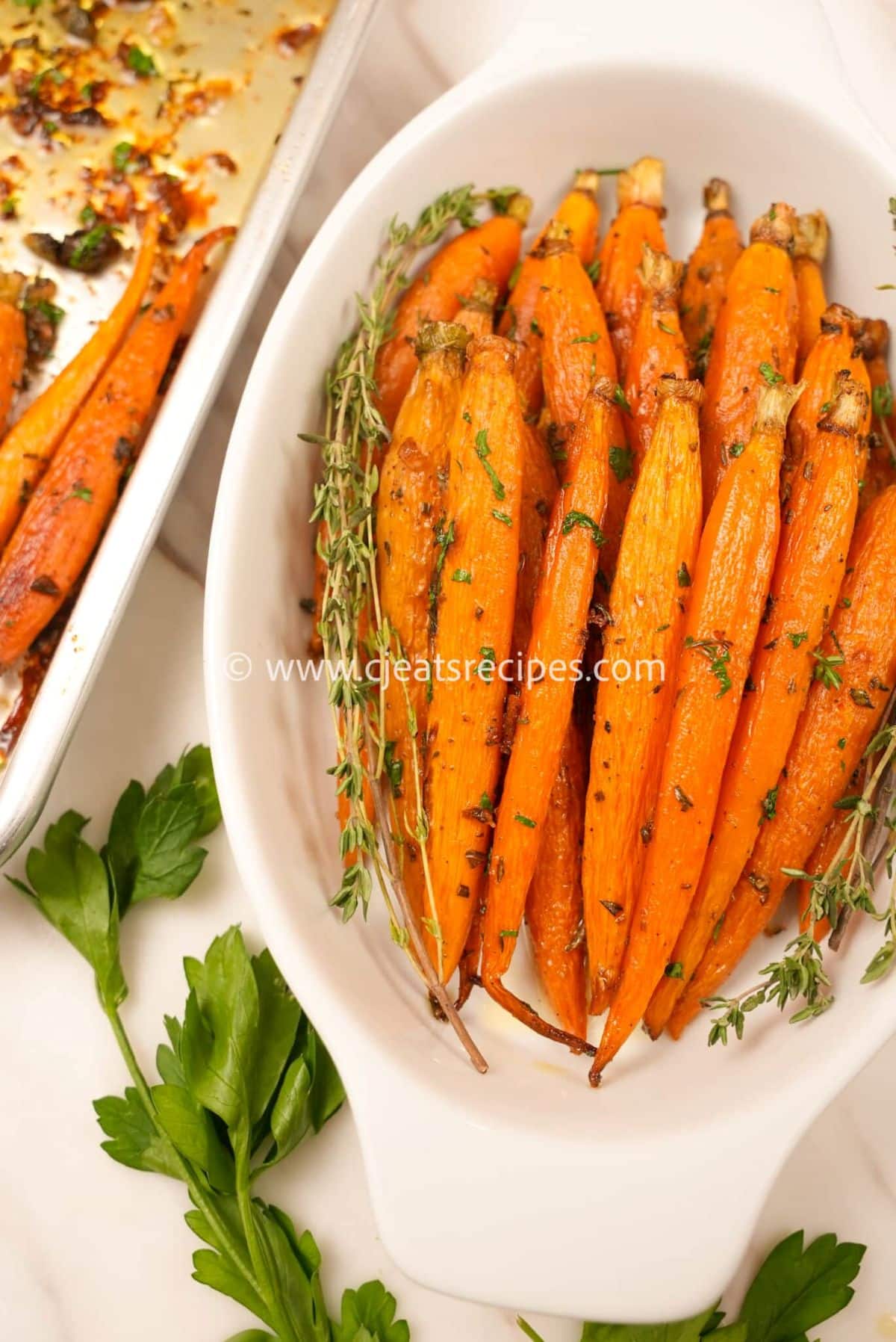 A bowl of honey roasted carrots with fresh herbs.