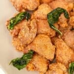 Air Fryer Taiwanese Popcorn Chicken in a bowl with air fried basil leaves.