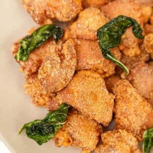 Air Fryer Taiwanese Popcorn Chicken in a bowl with air fried basil leaves.