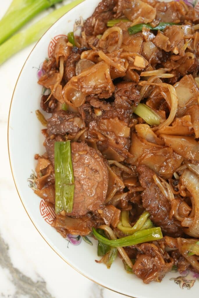 Beef Chow Fun Ho Fun noodles on a white plate.