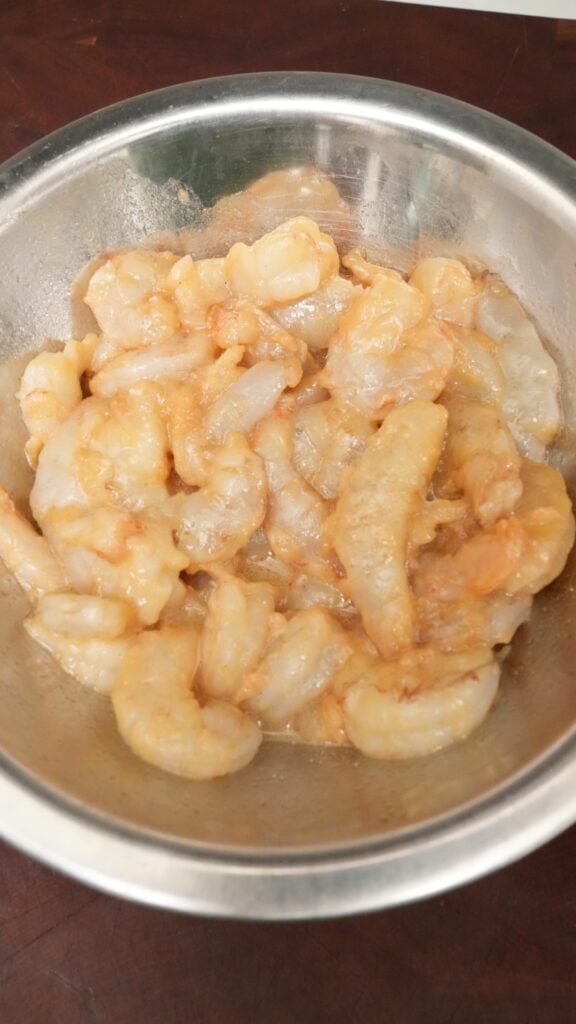 Marinated shrimp in a metal bowl.