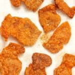 Crispy chicken skin chips on a paper towel seasoned with spices.