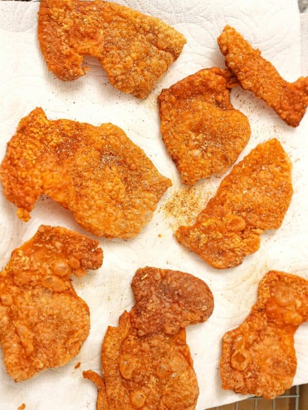 Crispy chicken skin chips on a paper towel seasoned with spices.