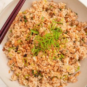 Garlic Fried Rice in a bowl with chopsticks and scallions.