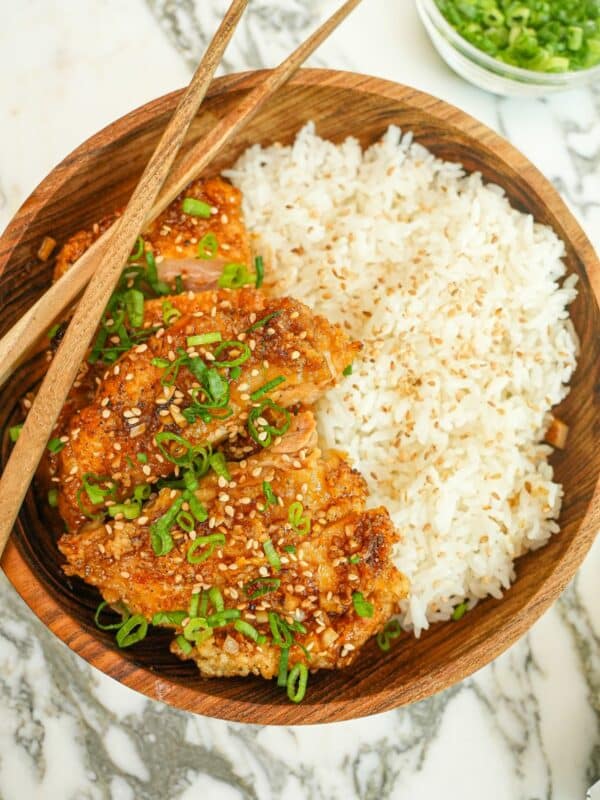 A plate of crispy Honey Garlic Chicken in a bowl with rice.
