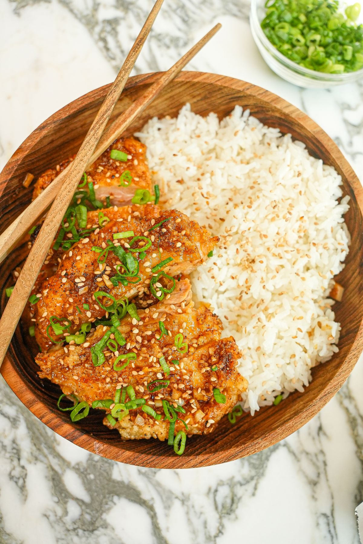 A plate of crispy Honey Garlic Chicken in a bowl with rice.