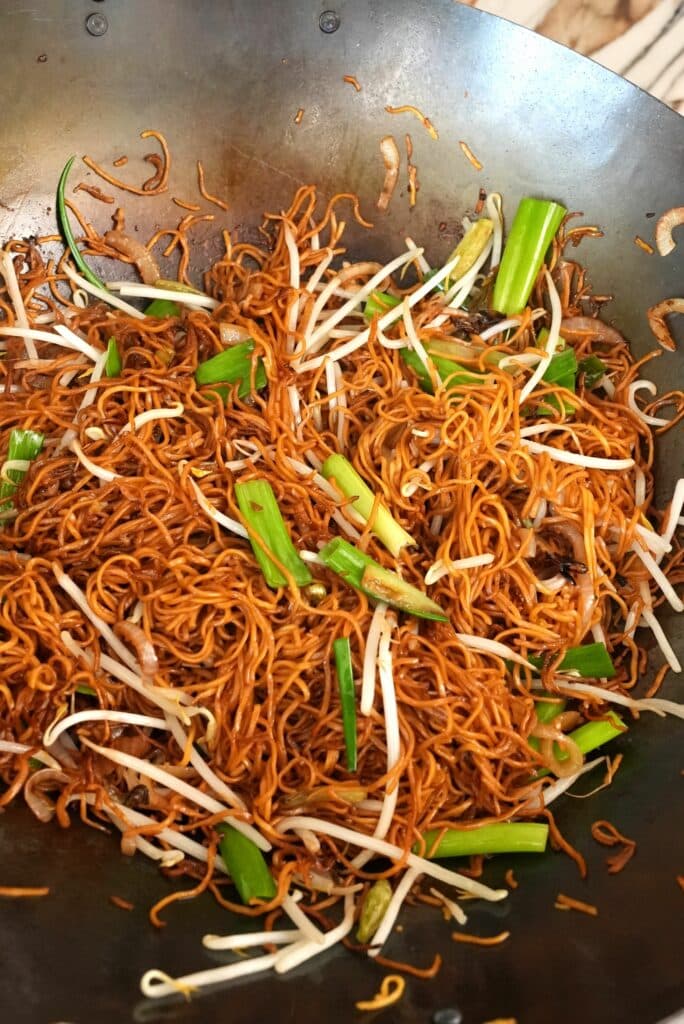 The green parts of the green onion and bean sprouts added to the stir fried noodles and vegetables.