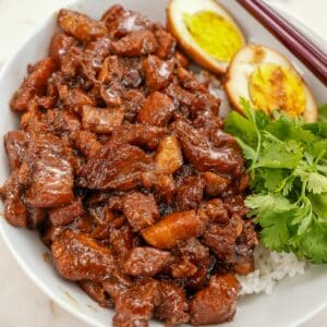 Taiwanese braised pork rice (Lu Rou Fan) in a bowl with rice, cilantro, and hard boiled egg.