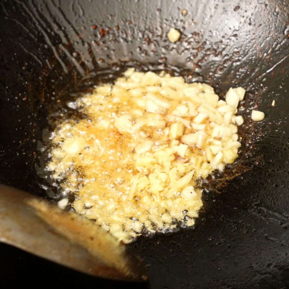 Garlic and ginger sauteing in a wok.