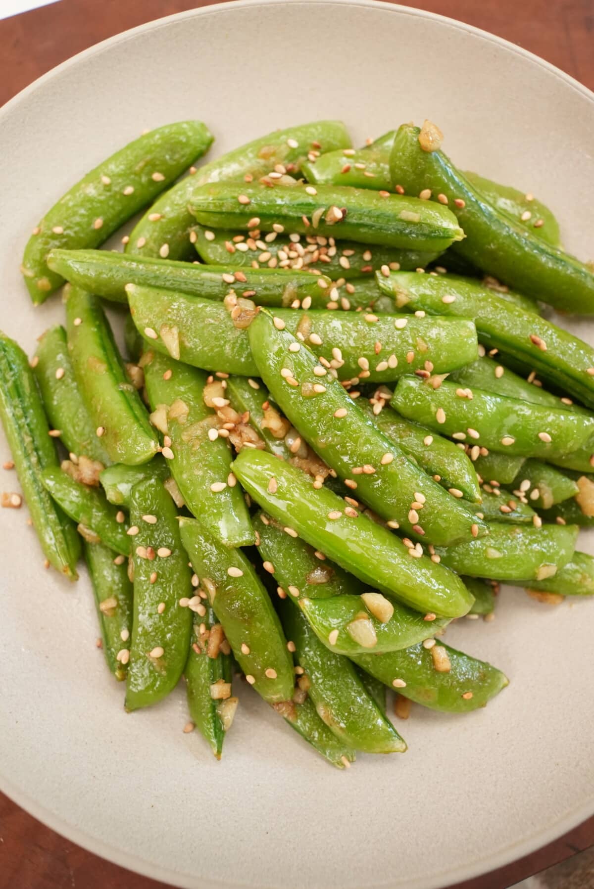 Sesame Garlic Snap Peas plated in a bowl topped with sesame seeds.