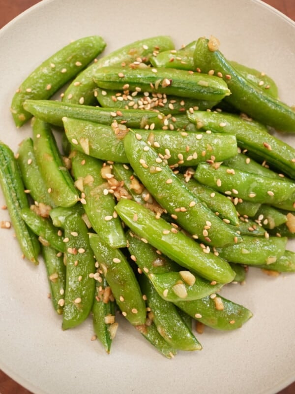 Sesame Garlic Snap Peas plated in a bowl topped with sesame seeds.