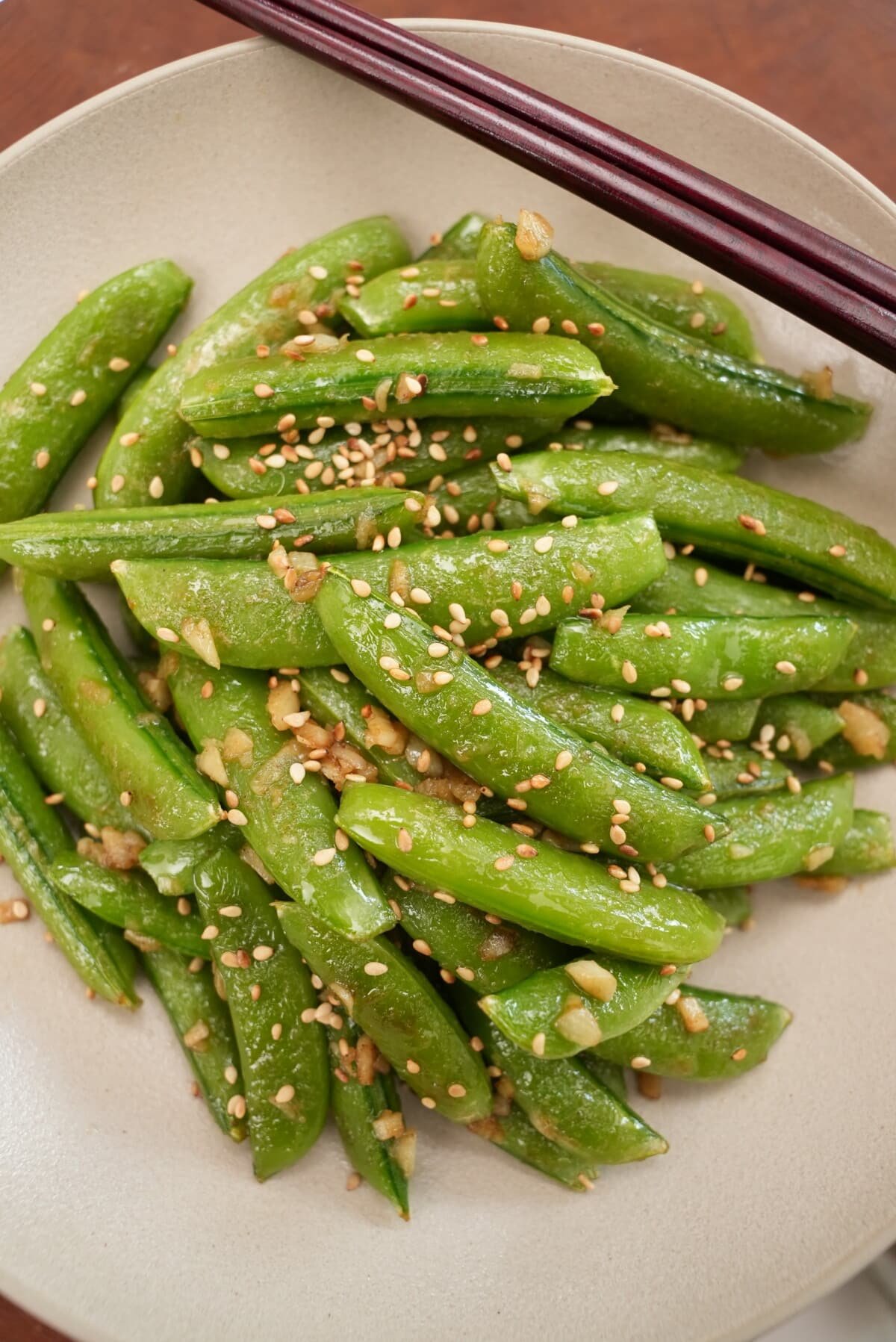 Sesame garlic snap peas in a bowl with chopsticks.